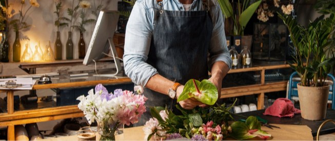 Fleuriste composant un bouquet à l'atelier